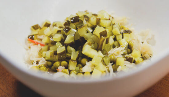 Винегрет с селёдкой, как делать: слейте жидкость с горошка, отожмите капусту, нарежьте огурцы